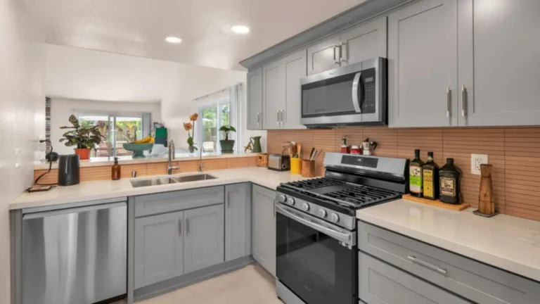 Double undermount sink and pass-through counter beside gray shaker cabinets in a Carlsbad kitchen remodel