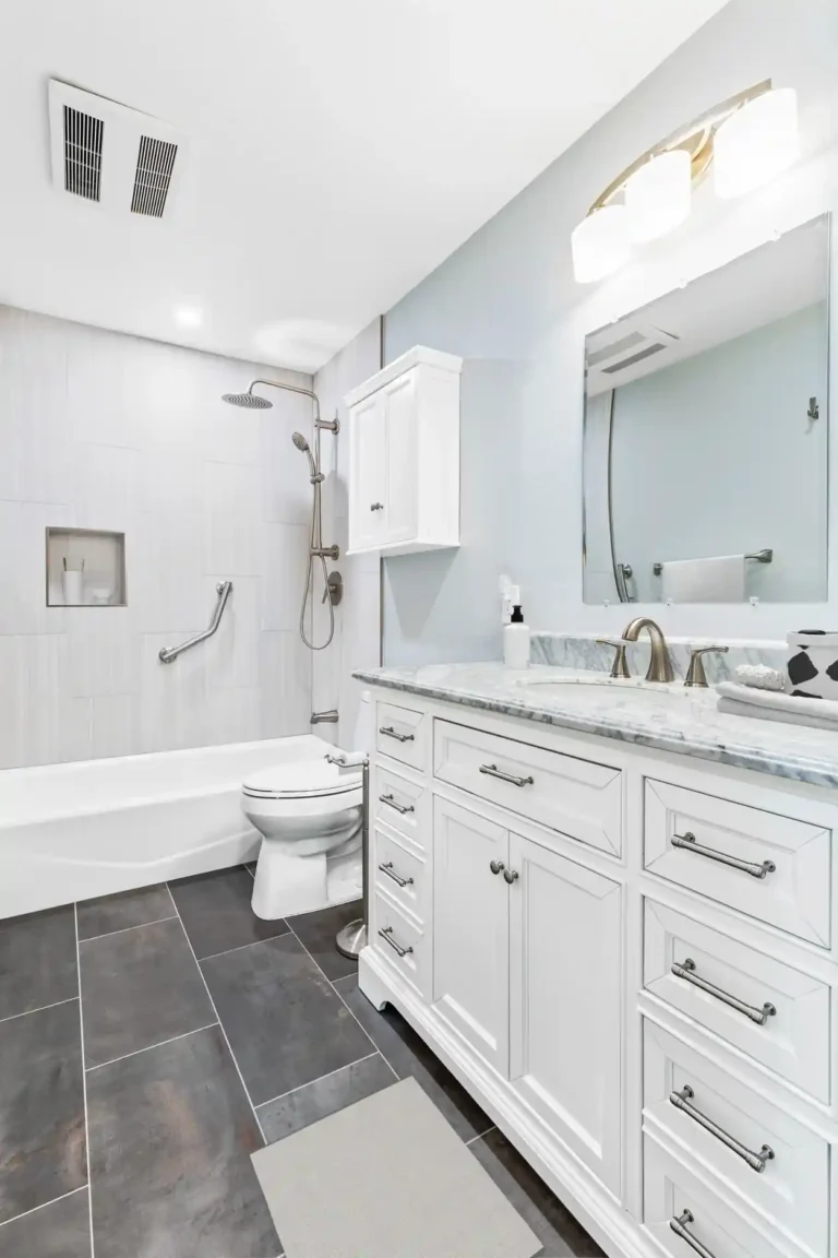 Full-length view of a white drawer vanity and dark gray floor tile in a remodeled Mission Viejo guest bathroom