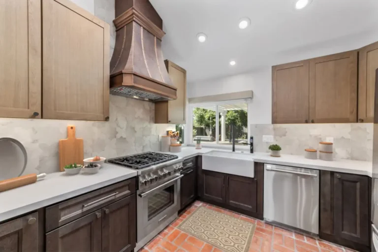Hammered copper range hood above a stainless gas range and star and cross tile backsplash in a Santa Ana kitchen remodel