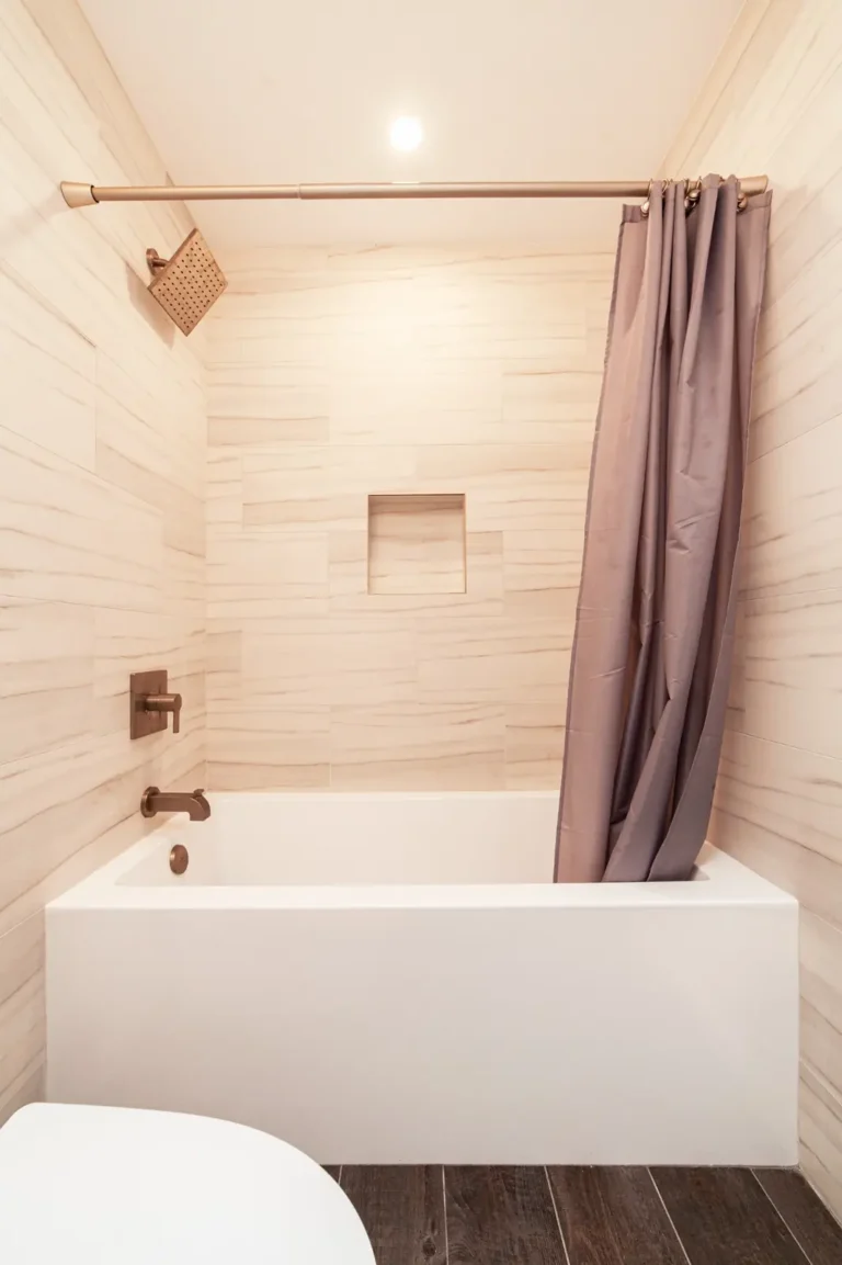Tiled tub-shower combo with a recessed niche and square rain showerhead in a remodeled Irvine bathroom.
