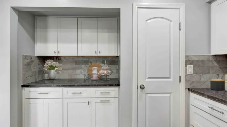 White shaker cabinet alcove with a dark countertop and marble-look backsplash in a Huntington Beach kitchen