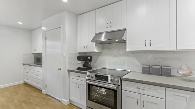 Long run of white shaker cabinets with a microwave station and range wall in a Laguna Hills kitchen remodel
