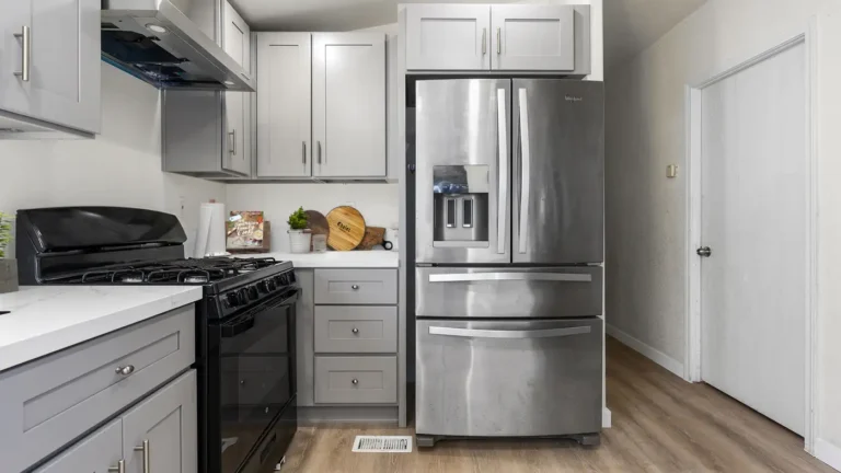 Stainless French door refrigerator framed by gray shaker cabinets and a drawer stack in a Torrance kitchen remodel