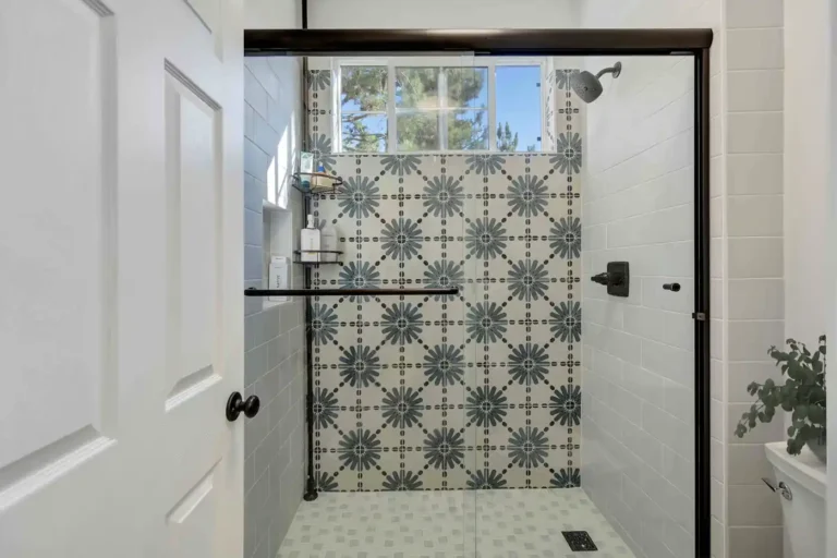 Blue starburst cement tile accent wall framed by white subway tile in a remodeled San Clemente shower enclosure.