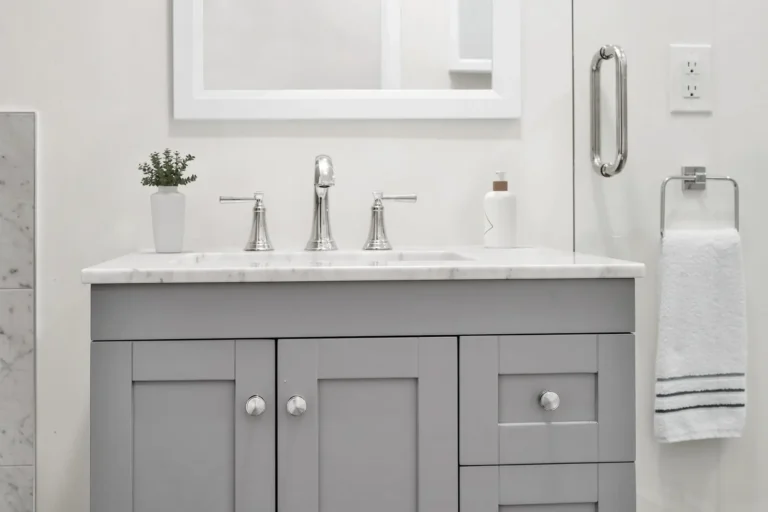 Close-up of the gray shaker vanity, marble countertop and chrome widespread faucet in an Irvine bathroom remodel
