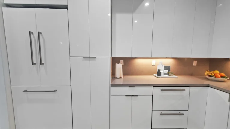 Panel-ready French door refrigerator beside tall white gloss pantry cabinets in a Mission Viejo kitchen remodel