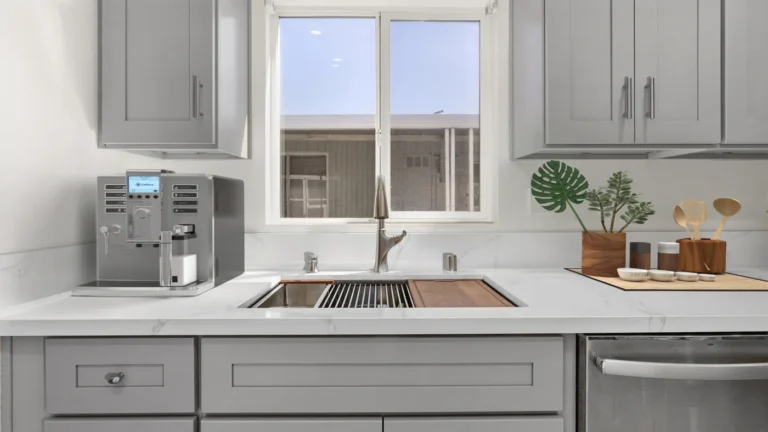 Workstation sink with a wood cutting board and pull-down faucet under a window in a Torrance kitchen remodel