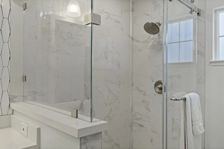 Porcelain marble‑look walk‑in shower in Mission Viejo with rain showerhead and clear glass.
