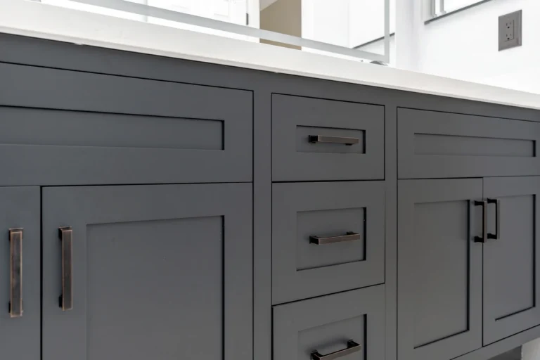 Oil-rubbed bronze bar pulls on charcoal Shaker cabinet doors and drawers in a San Clemente bathroom remodel.