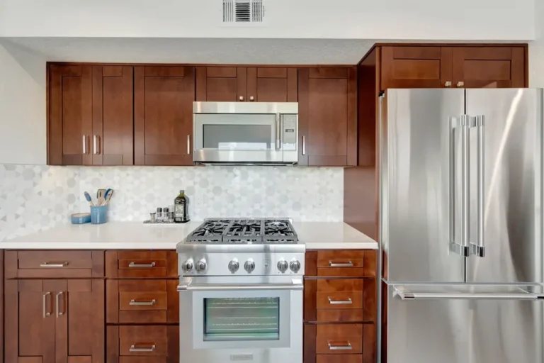 Front view of a gas range centered between walnut drawer stacks and a French door fridge in a Mission Viejo kitchen