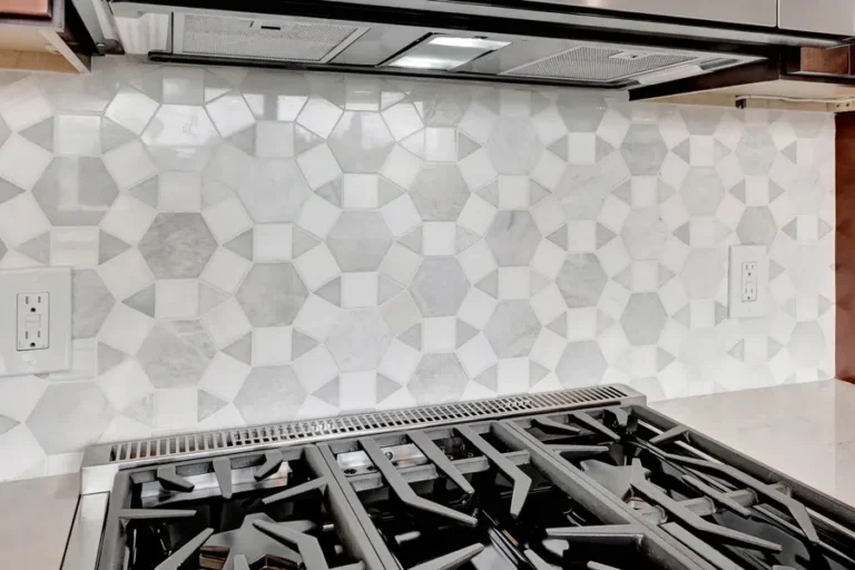 Close view of a white and gray marble geometric mosaic backsplash above a gas cooktop in a Mission Viejo kitchen