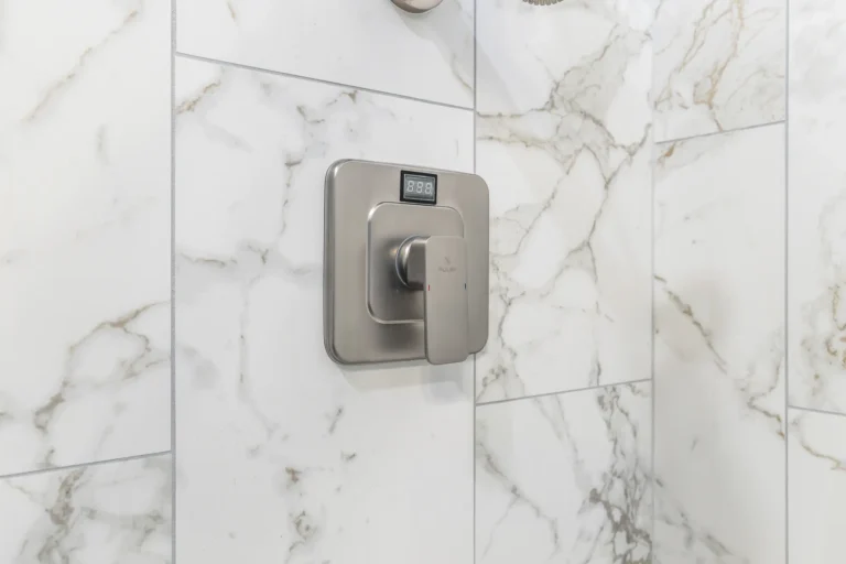 Shower valve trim set into full-height marble-look wall tile in a Mission Viejo bathroom remodel
