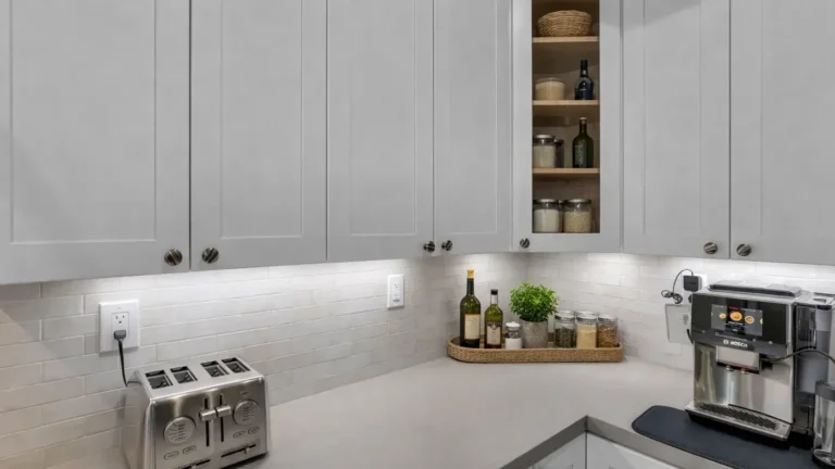 Corner coffee station with white shaker cabinets, a glass-front corner cabinet, and under-cabinet lighting in Carlsbad.