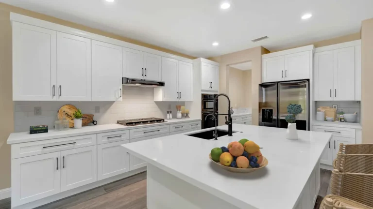 Subway tile backsplash, gas cooktop, and stainless side by side refrigerator in a white shaker Corona kitchen remodel