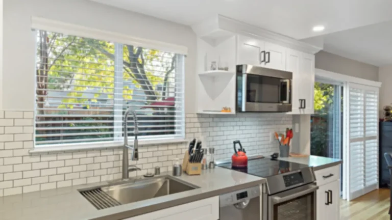 Sink window with an open corner shelf and over-the-range microwave in a Laguna Niguel kitchen remodel with subway tile