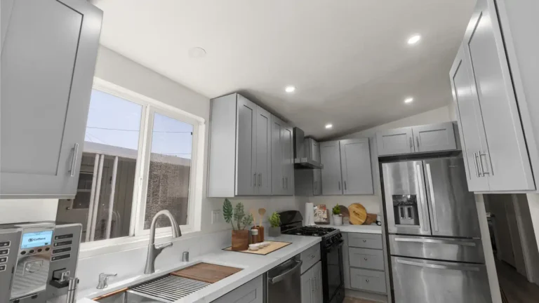 Recessed lights over gray shaker cabinets, quartz counters, and a stainless refrigerator in a remodeled Torrance kitchen
