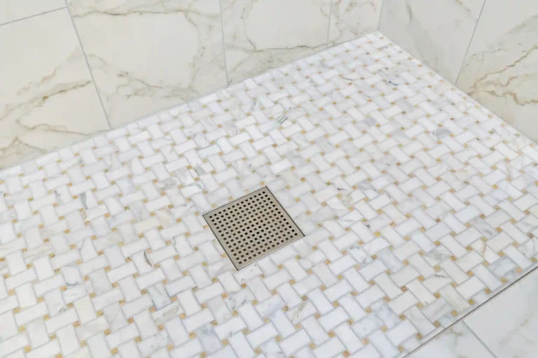 Square center drain in a white mosaic tile shower floor in a Mission Viejo bathroom remodel