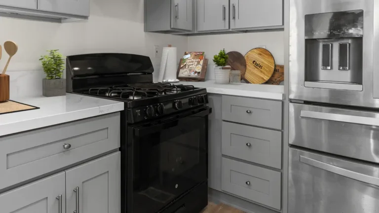 Gray shaker drawer base beside a black gas range and white quartz countertop in a remodeled Torrance kitchen