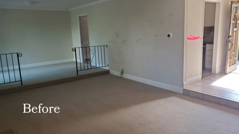 Before photo of a carpeted step-down room with wrought iron railings next to the original Laguna Niguel kitchen doorway
