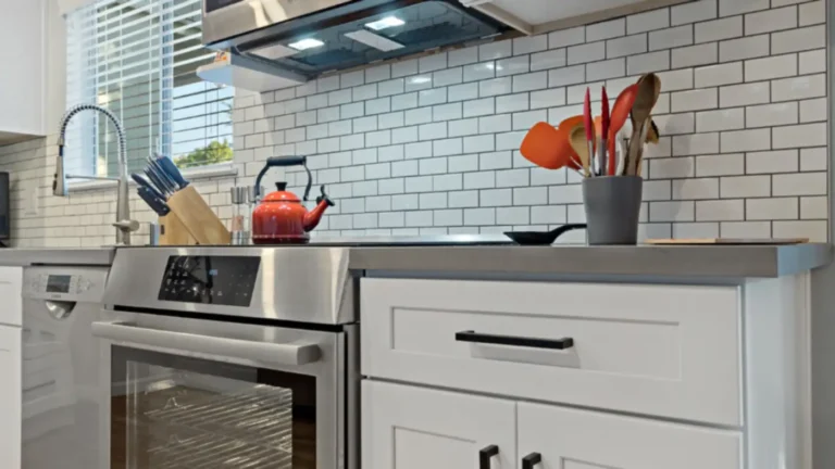 Stainless range with a glass cooktop beside white shaker drawers and subway tile in a Laguna Niguel kitchen remodel