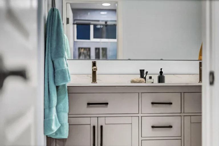 View through the doorway to the double vanity and mirror reflecting the shower in a San Clemente bathroom remodel