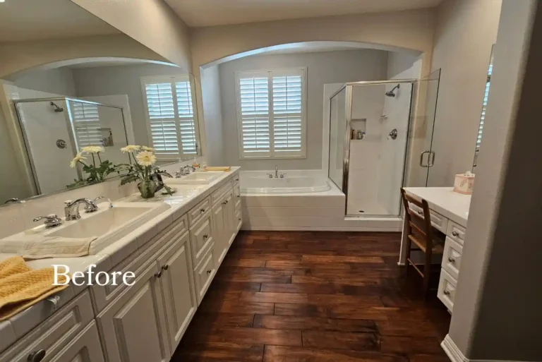Dated tile-topped double vanity and framed shower enclosure in a Carlsbad primary bathroom before remodeling.