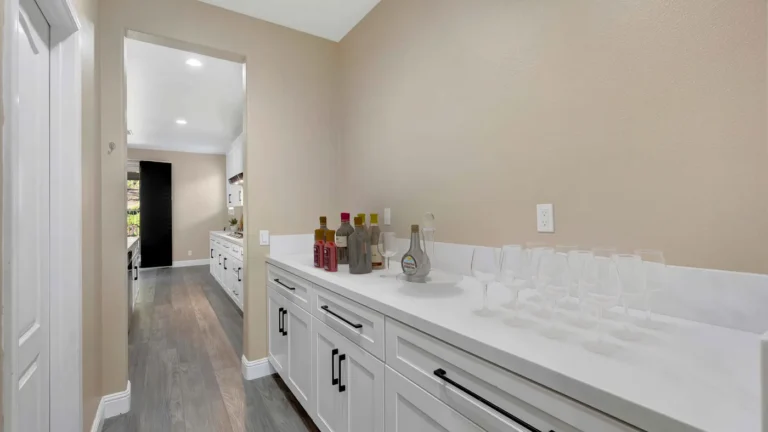 Butler pantry with white shaker cabinets, black bar pulls, and quartz counters off the remodeled Corona kitchen