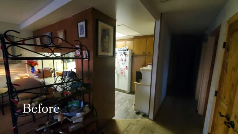 Before remodeling, a dated Laguna Hills kitchen with wood wall paneling, honey oak cabinets, and a closed-off entry wall