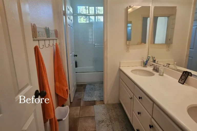 Before photo of a dated San Clemente bathroom with a white laminate vanity and brown floor tile.