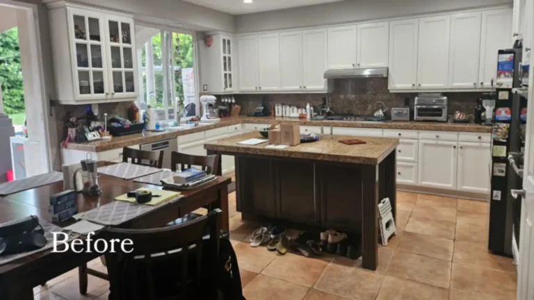 Before photo of a Carlsbad kitchen with granite countertops, a dark wood island, and raised-panel white cabinets.
