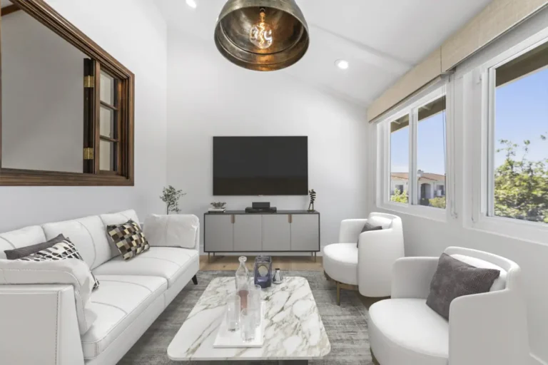 Santa Ana sitting room with a vaulted ceiling, brass dome pendant, wall-mounted TV, white sofa, and a marble table.