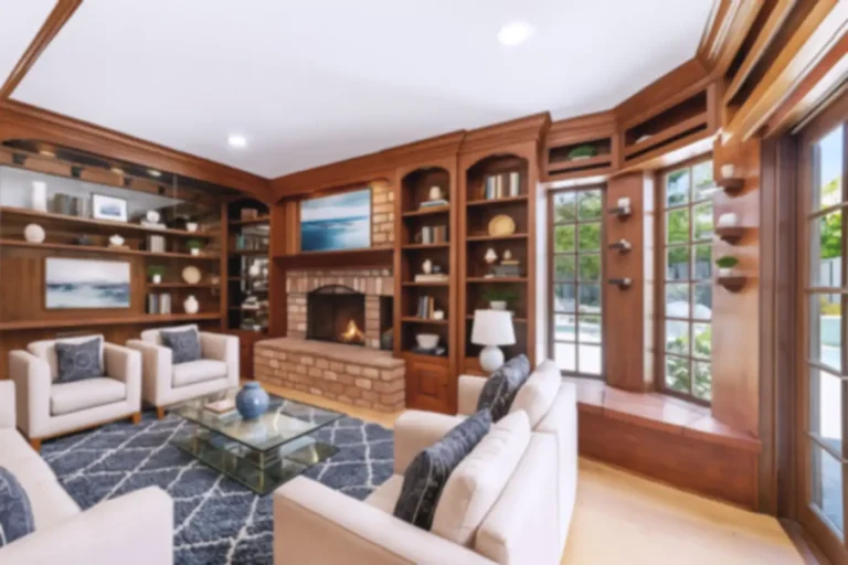 Santa Ana family room with built-in wood shelving, brick fireplace, window seat, and French doors to the backyard.