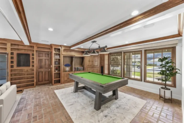 Santa Ana game room with wood-paneled walls, built-in cabinetry, beamed ceiling, pool table, and brick paver floor.