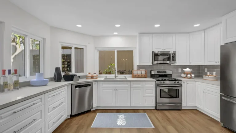 U-shaped Santa Ana kitchen remodel with white raised panel cabinets, quartz countertops, and wood-look flooring