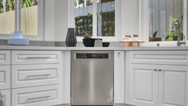 Stainless steel dishwasher set between white drawer stacks and quartz countertops in a Santa Ana kitchen remodel
